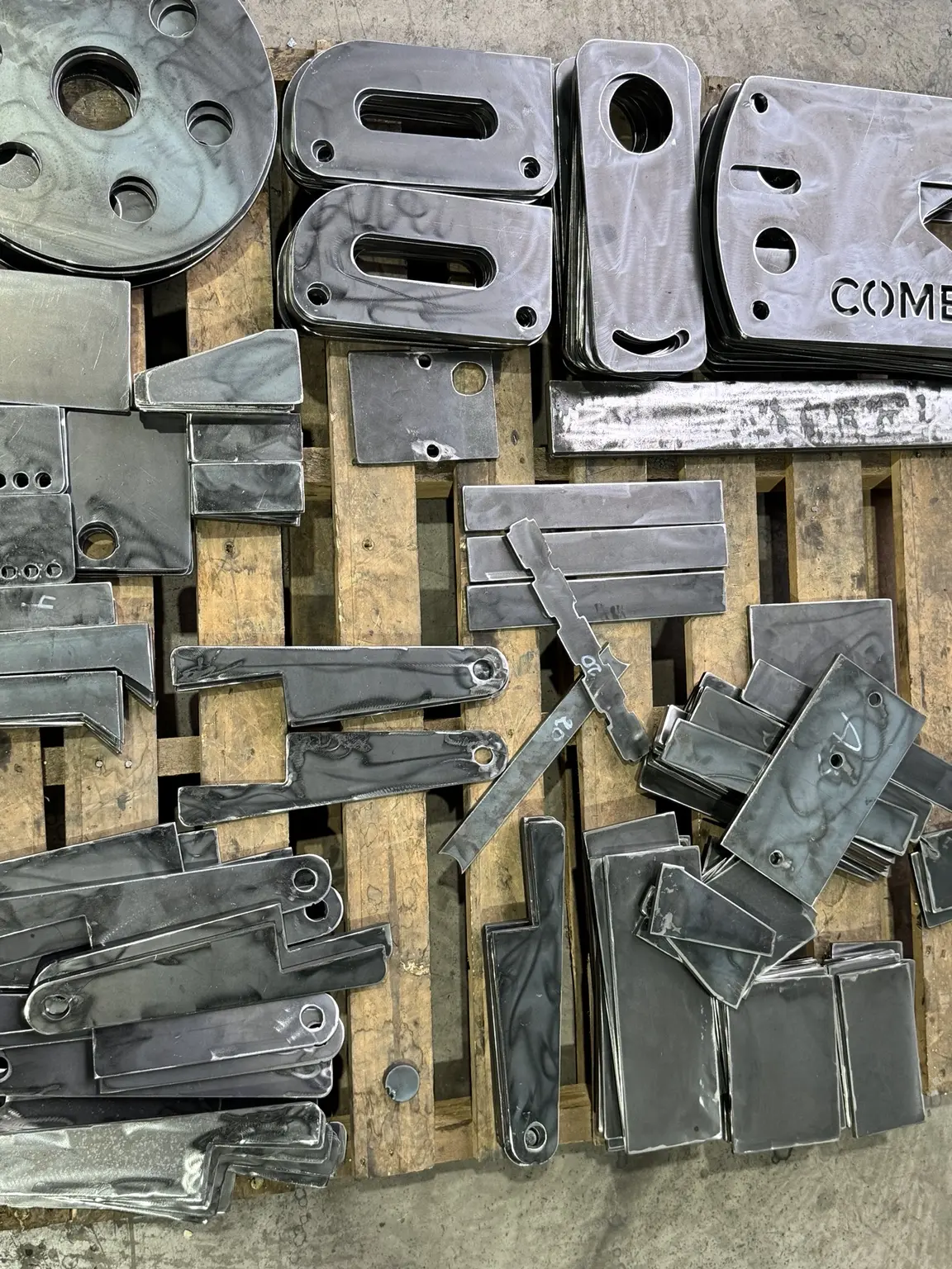 Detalle de piezas metálicas terminadas con perforaciones y ranuras