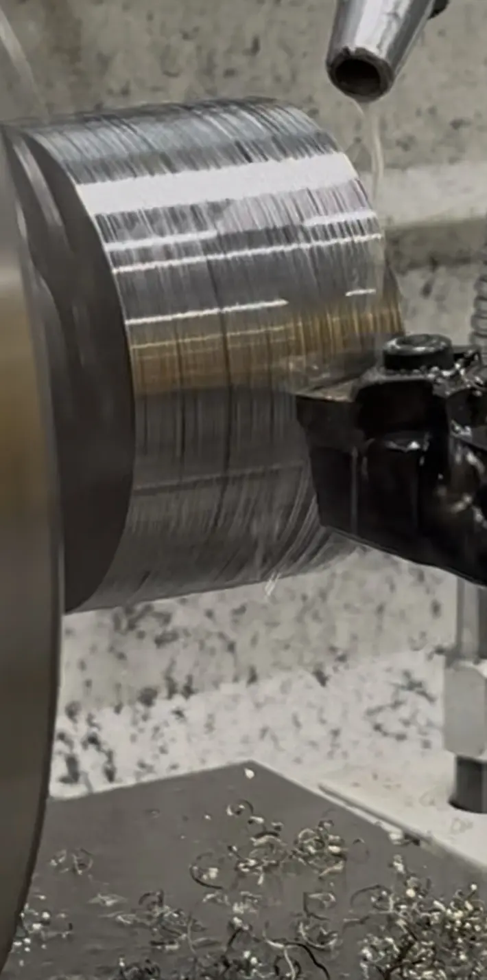 Herramienta de corte mecanizando el exterior de una pieza metálica en rotación